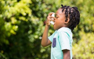 boy using inhaler outside prescribed by best pediatric allergist near me